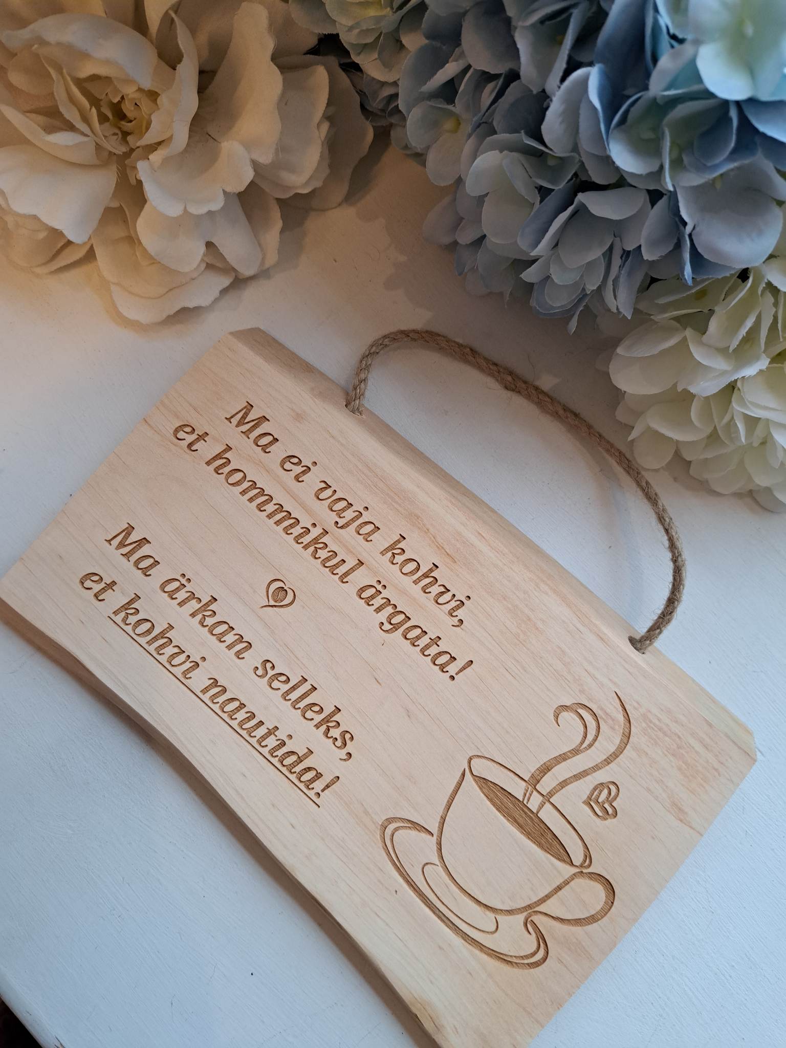 Puidust silt tekstiga "Ma ei vaja kohvi..."