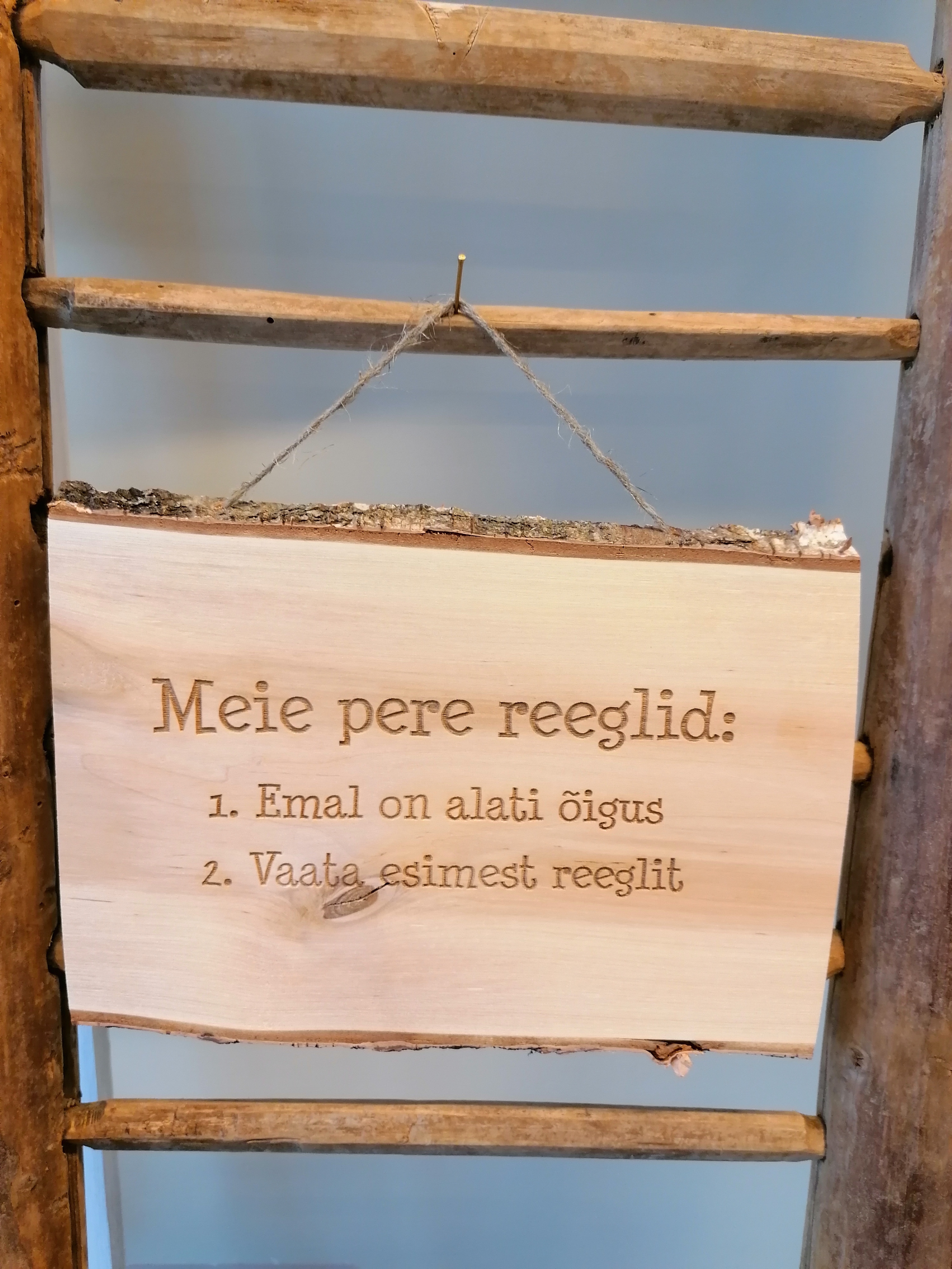 Puidust silt tekstiga "Meie pere reeglid"