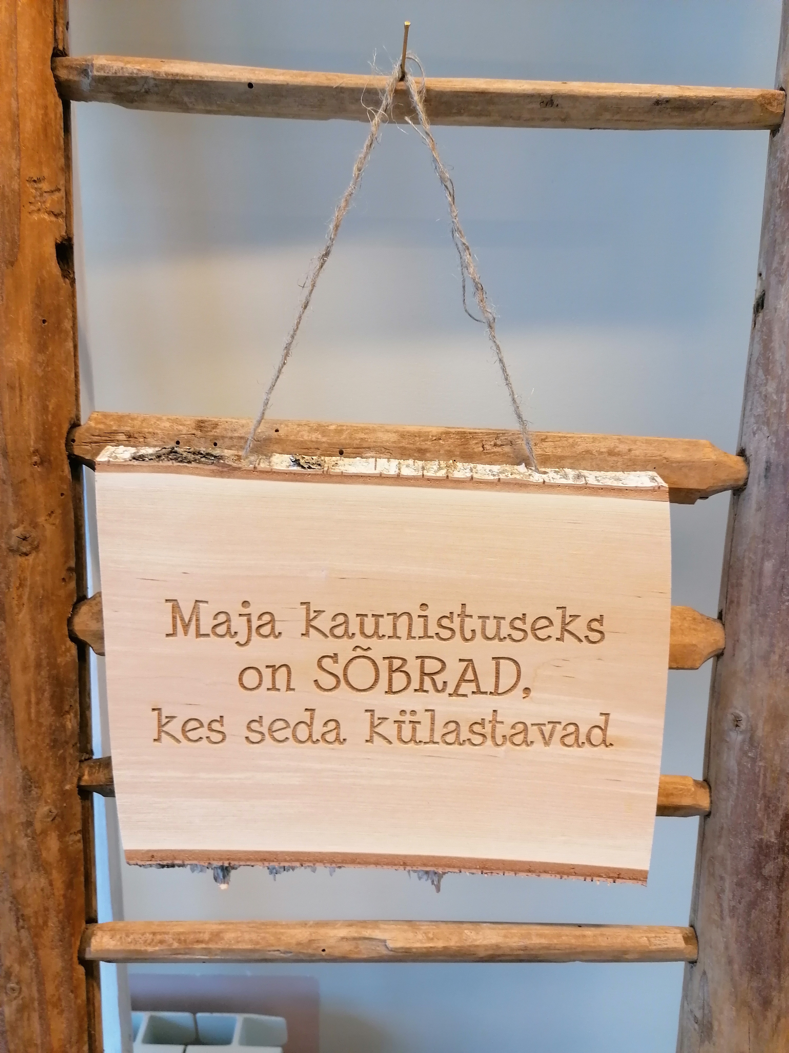 Puidust silt tekstiga "Maja kaunistuseks on SÕBRAD..."